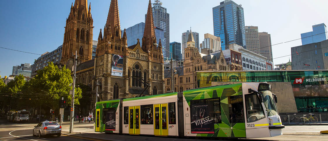 A Melbourne Yarra tram in front of the University of Melbourne, students getting on board of the train